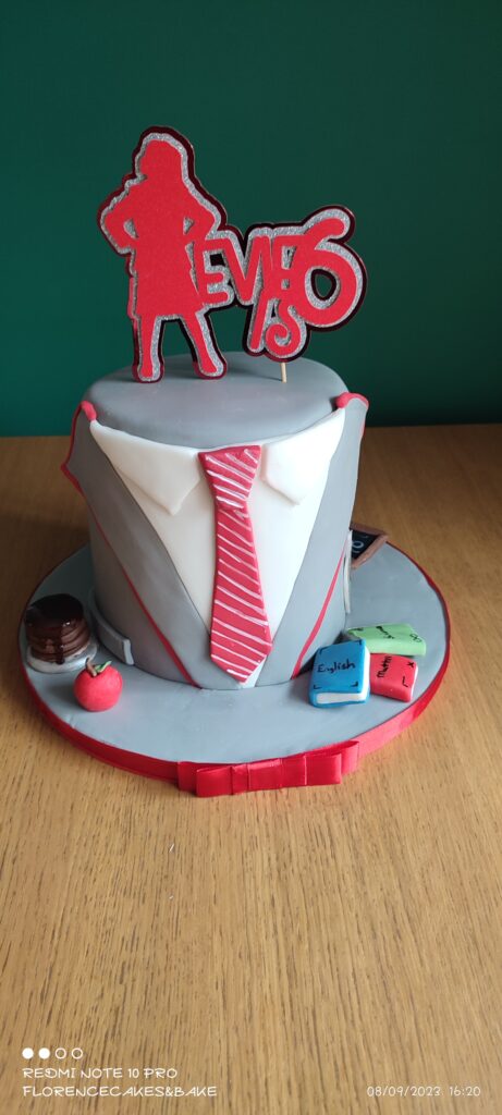 Cake with a school tie and blazer effect on the front with a topper of a girl in school uniform in red